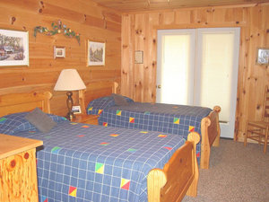 Twin bedroom with two wooden beds and a door to the deck